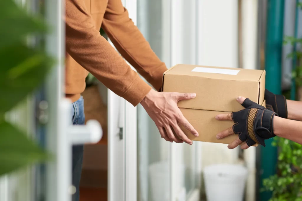 person receiving a cardboard box home delivery utc
